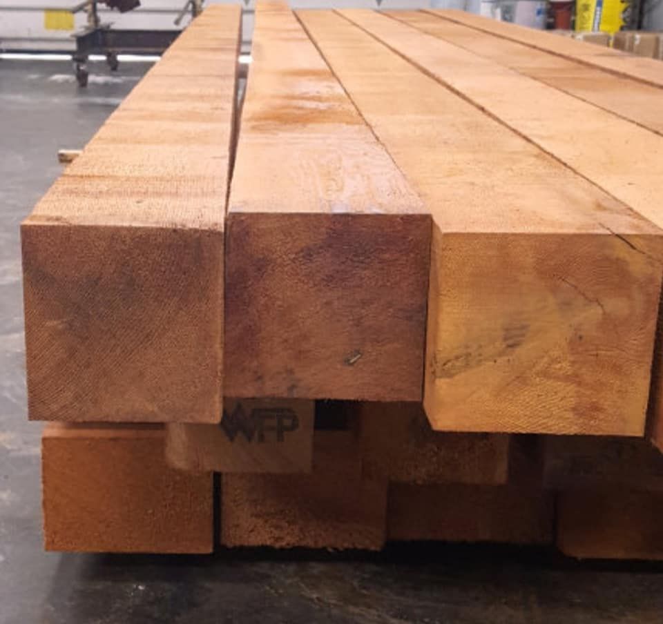 Close-up of a stack of square-cut, reddish-brown lumber.