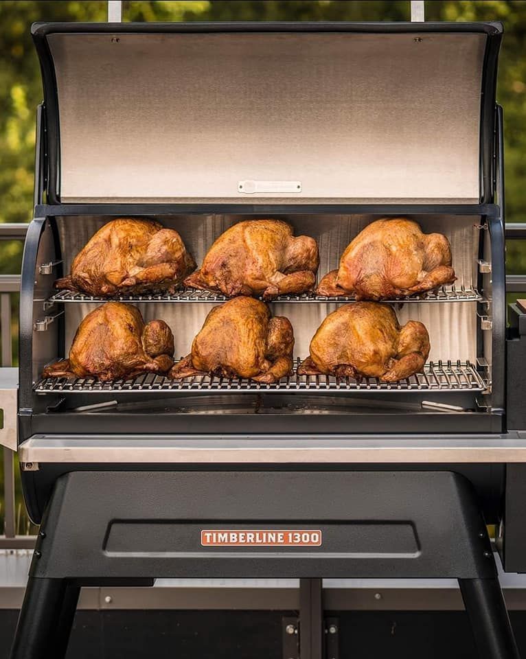 Six cooked turkeys in a black Timberline 1300 smoker, outdoors.