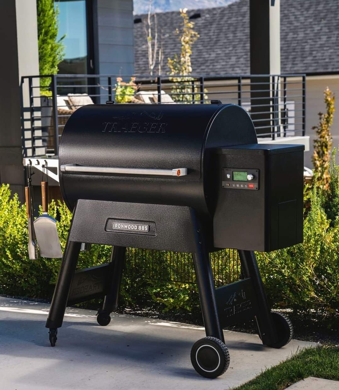 Black Traeger grill on patio with digital temperature controls.