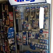 Shelves stocked with various tools, hardware, and accessories for sale in a store.