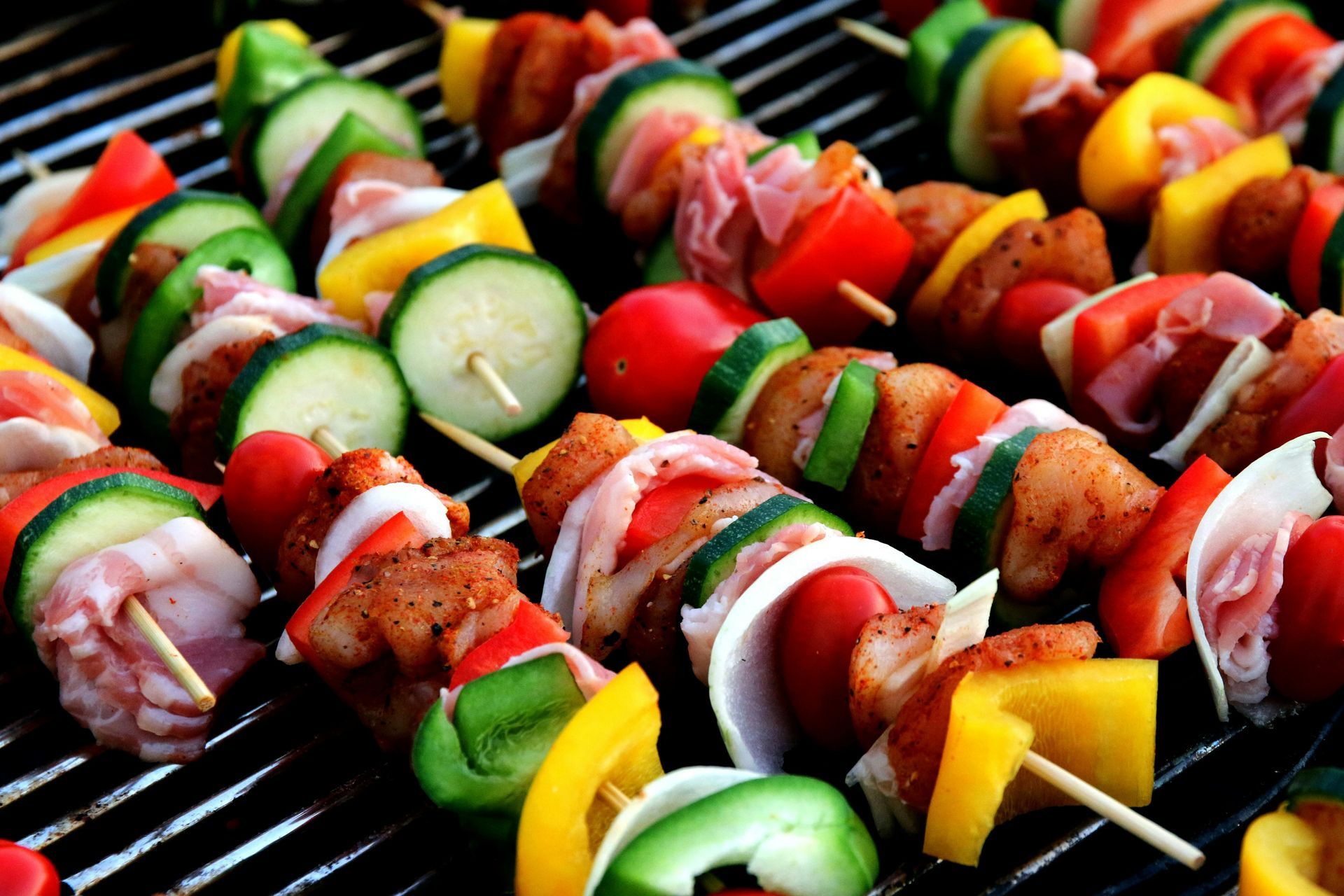 Skewers with grilled chicken, vegetables, and ham. Colorful, on a grill.