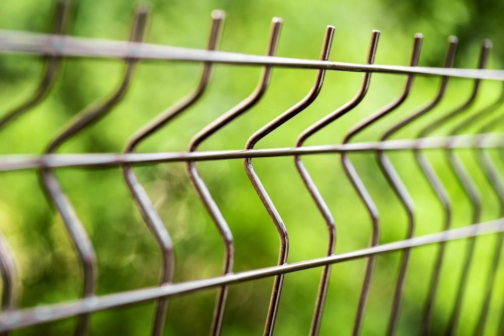 a Close Up of a Wire Fence With a Green Background — Tony Sinclair Fencing In Bucca, NSW