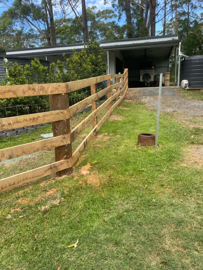 a Wooden Fence Surrounds a Grassy Area in Front of a House — Tony Sinclair Fencing In Bucca, NSW