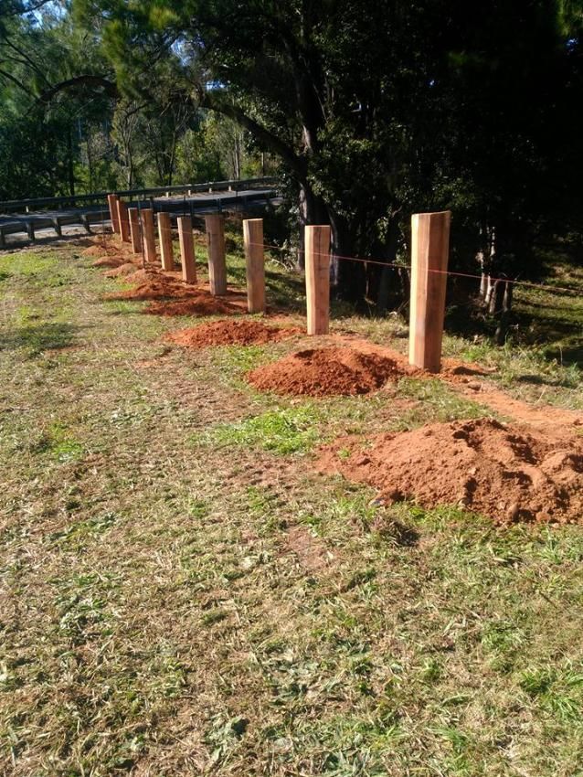 a Wooden Fence is Being Built in a Grassy Field — Tony Sinclair Fencing In Bucca, NSW