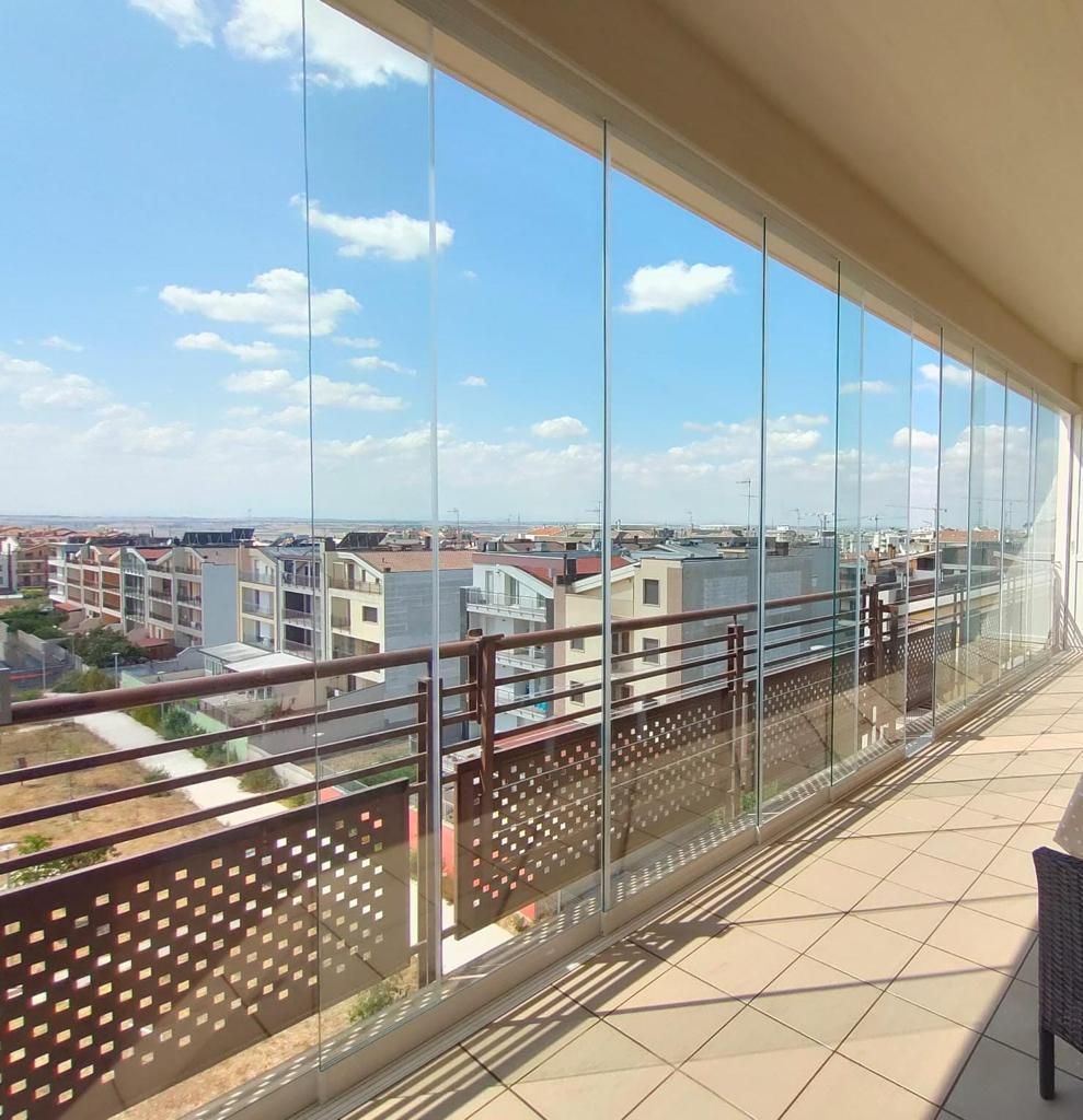 un balcone con molte finestre in vetro che si affaccia su una città