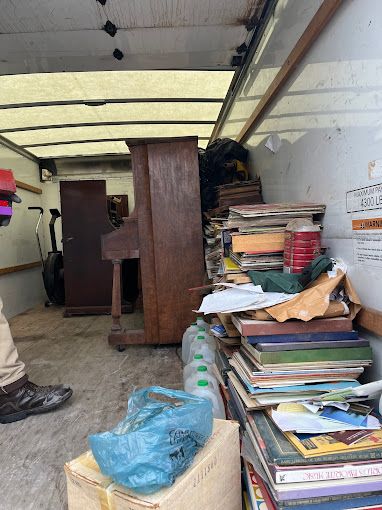 Two male movers in the kitchen, repairing the freezer.