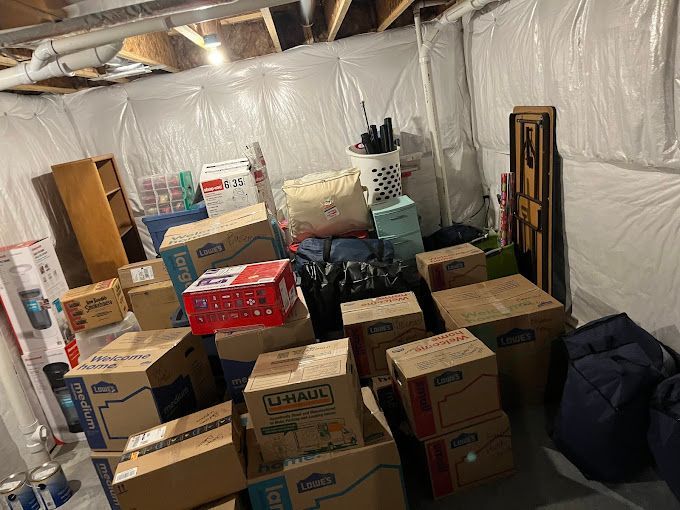 Cardboard boxes filled with household furniture and appliances, ready to be loaded onto a moving truck.