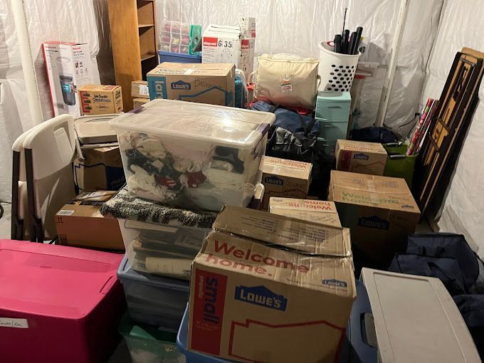 Delivery man stacking cardboard boxes for moving into an apartment.