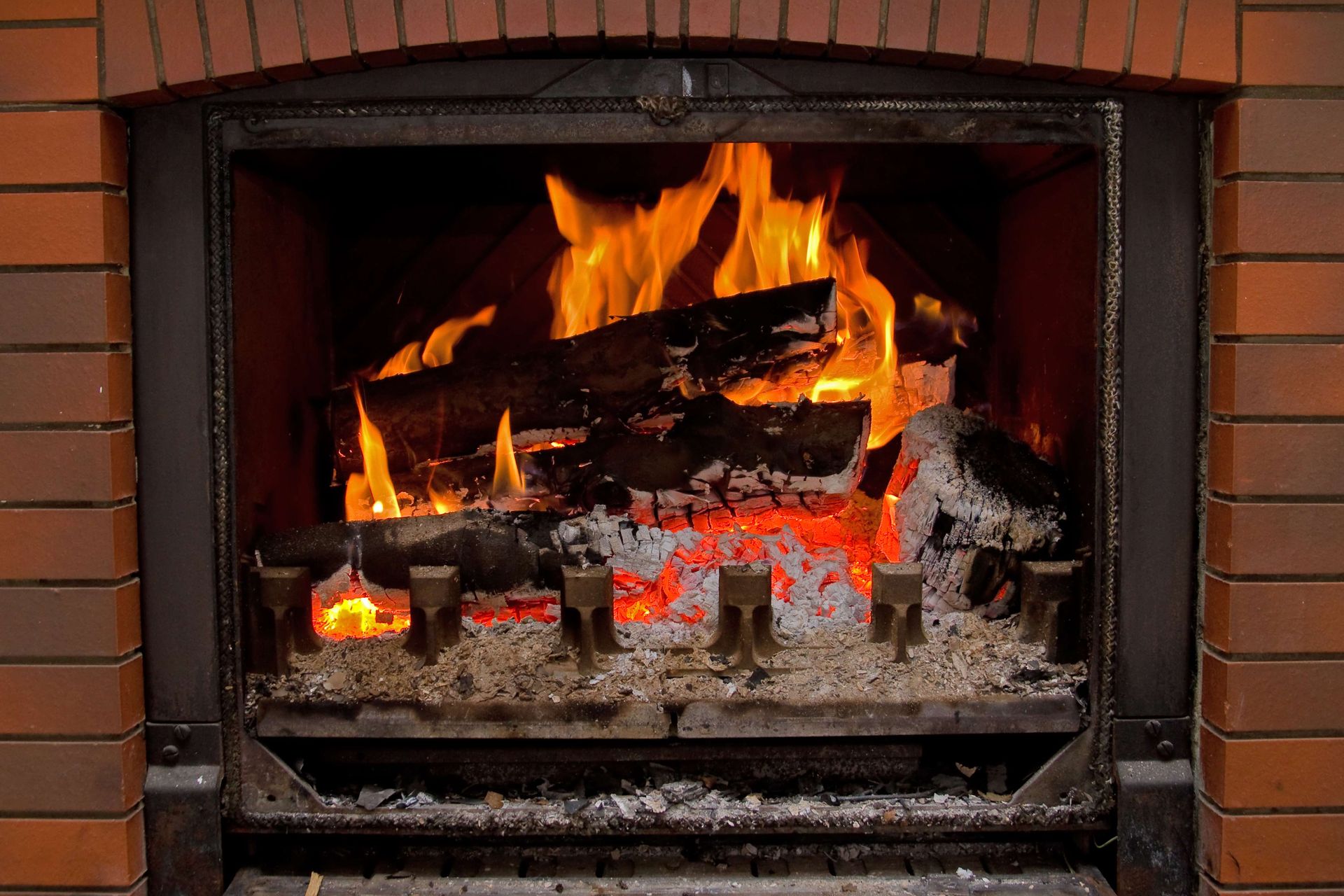 A warm fire crackles in a brick fireplace at Leonard's Stone and Fireplace, Burleson, TX. Visit for