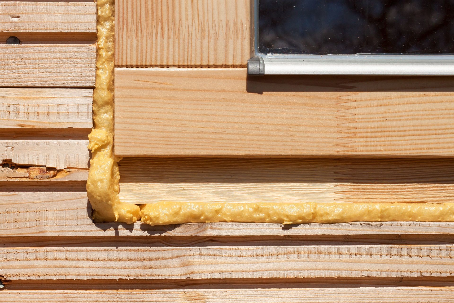 A close up of a wooden window with foam on it.