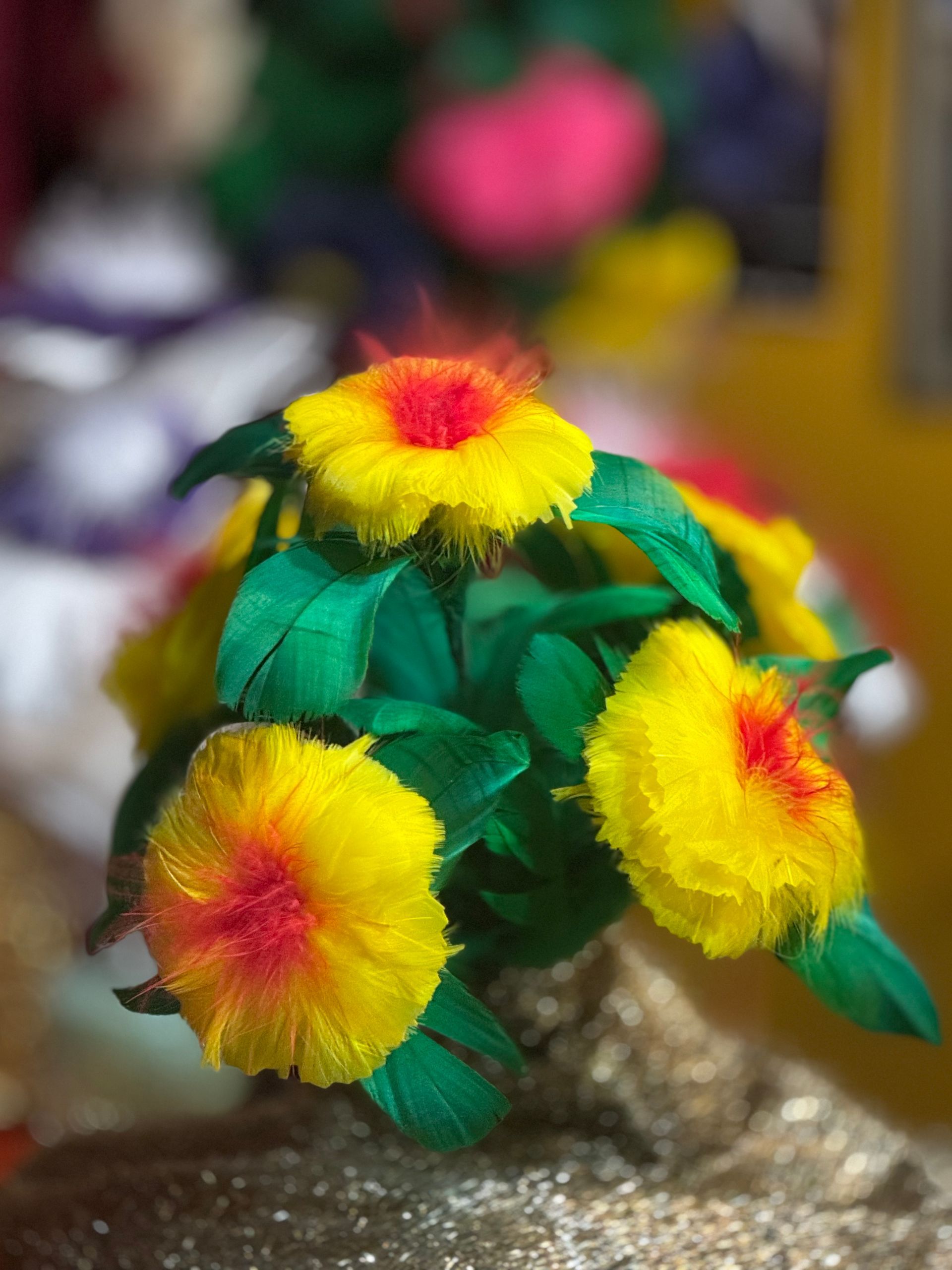 A bunch of yellow flowers with green leaves on a table.