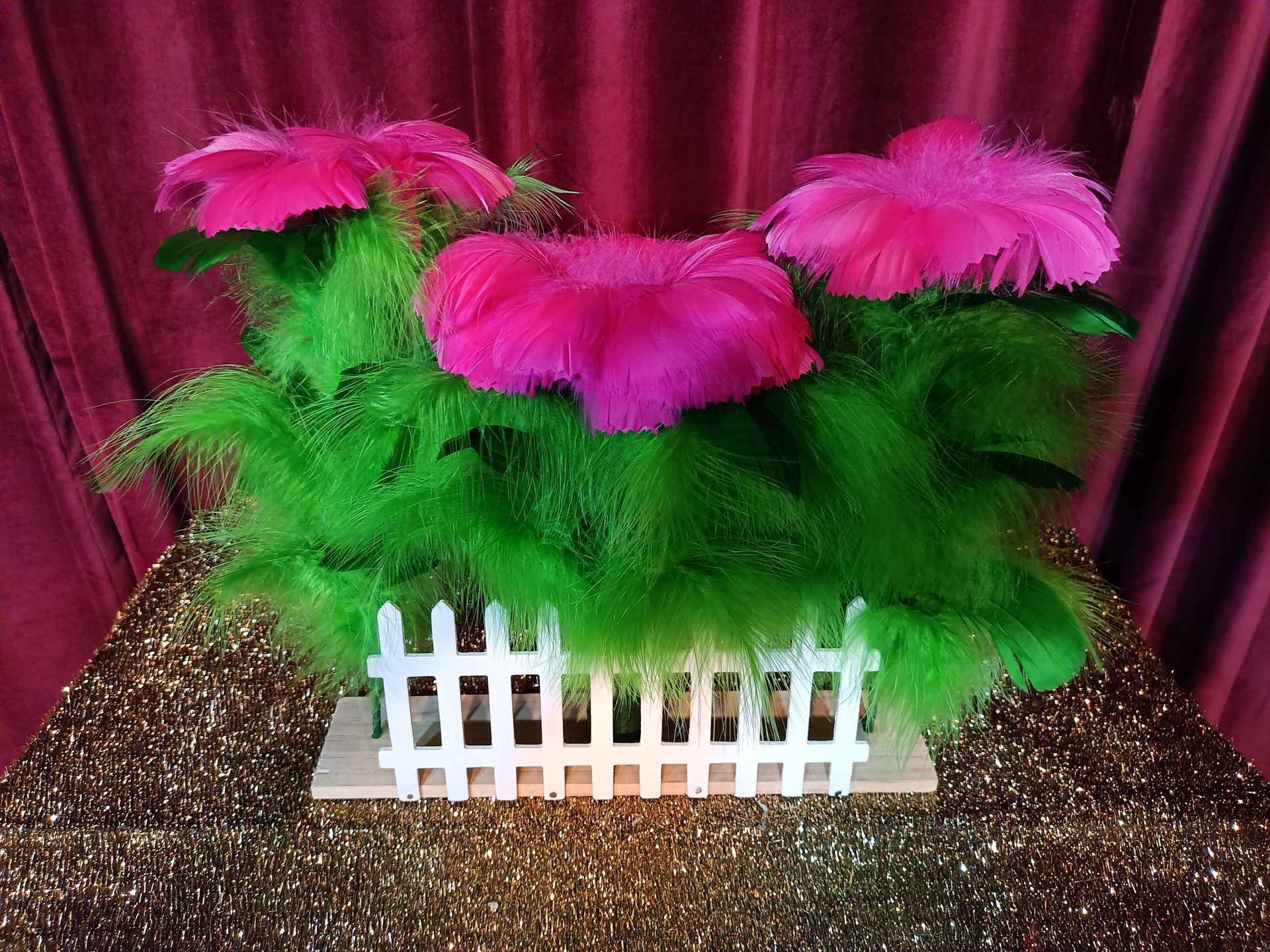 A bunch of flowers are sitting on top of a table next to a white fence.