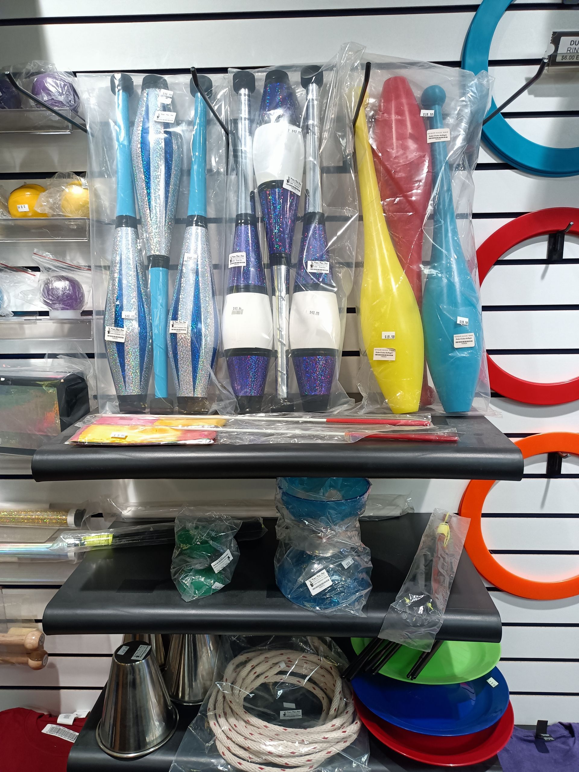 A shelf filled with a variety of objects including juggling clubs.