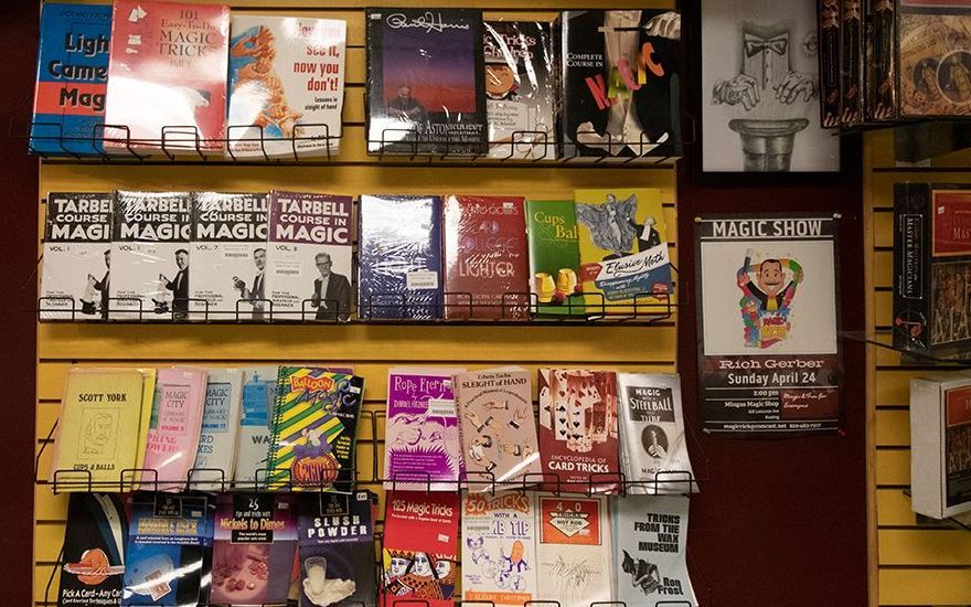 A shelf full of books including one called magic tricks