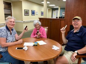 A group of people are sitting around a table playing cards.