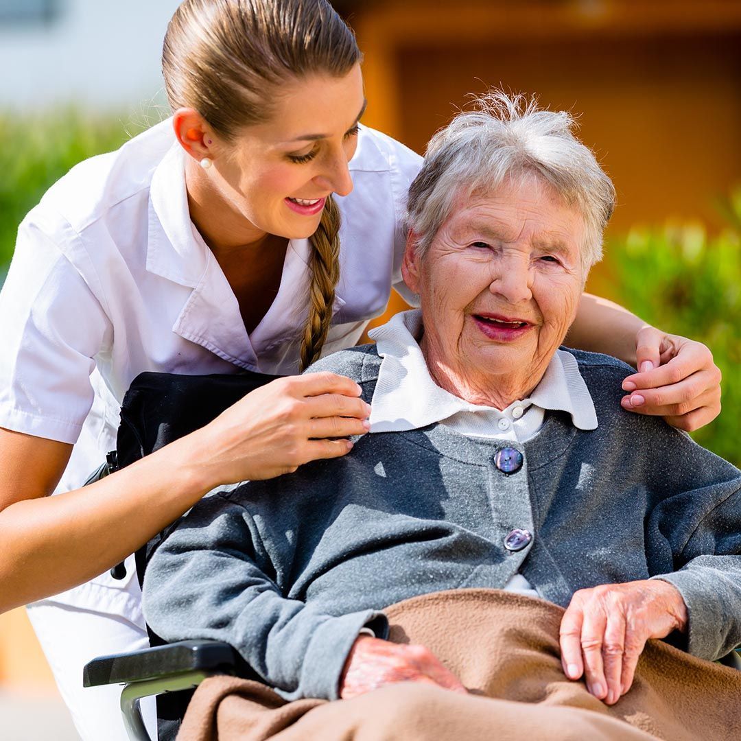 Nurse assisting senior woman in a wheel chair