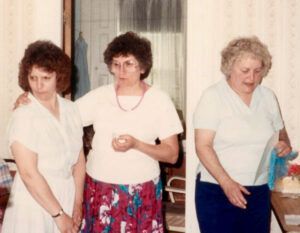 Three women are standing next to each other in a room