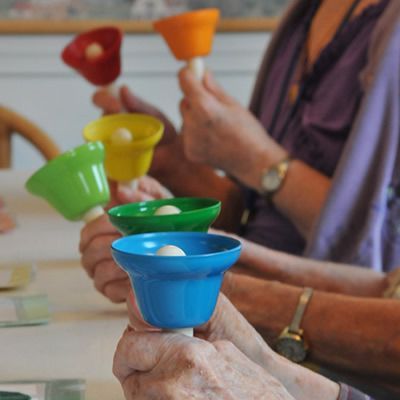 A group of people are holding bells in their hands
