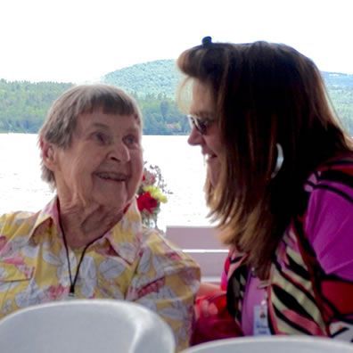 Two women are sitting at a table talking to each other.