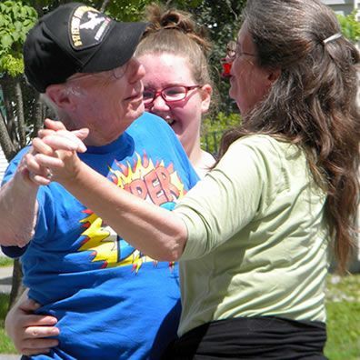 A man in a superman shirt is dancing with two women