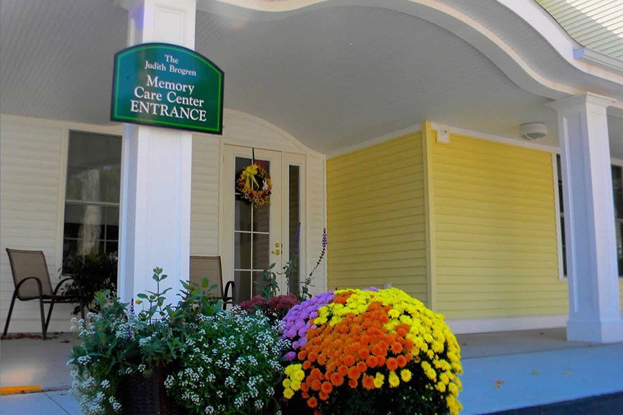 The memory care center entrance has flowers in front of it