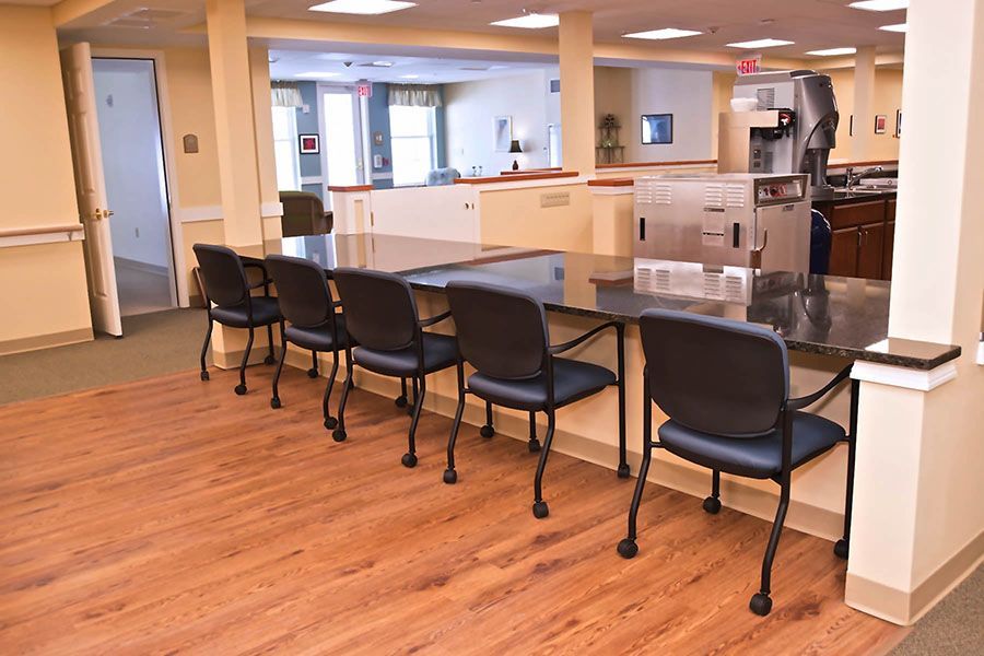 A row of chairs sitting next to a table in a room.