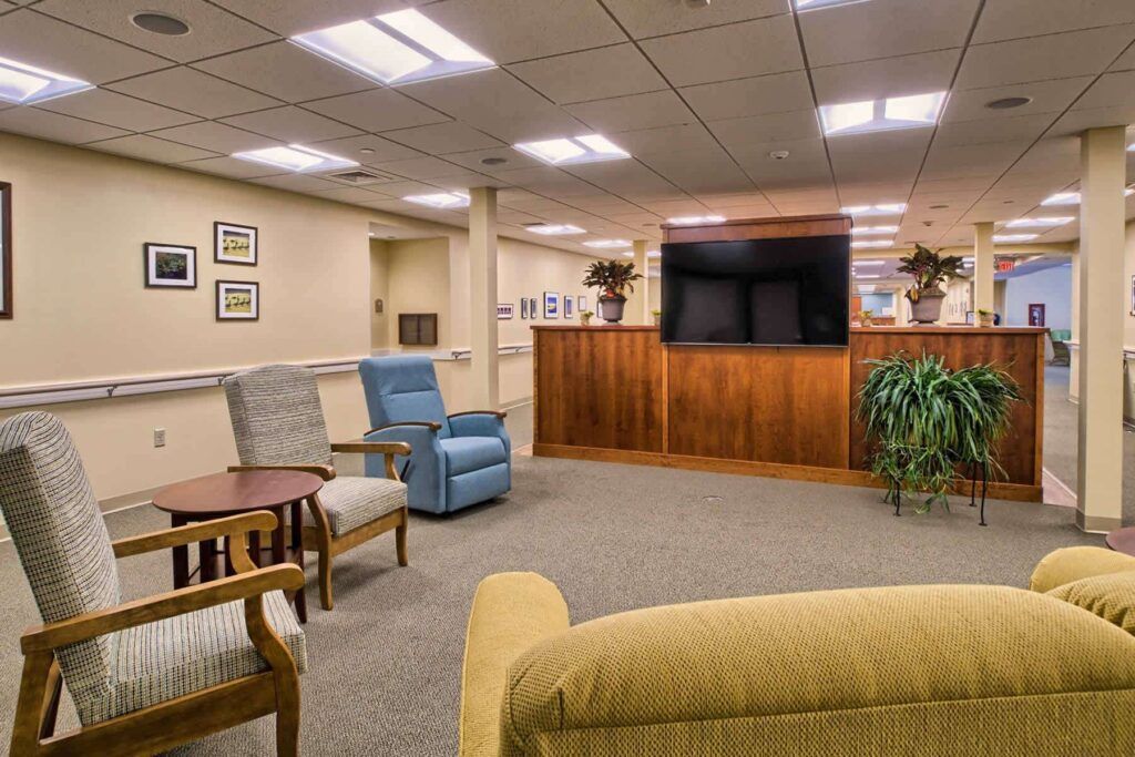 A living room with a couch , chairs , tables and a television.