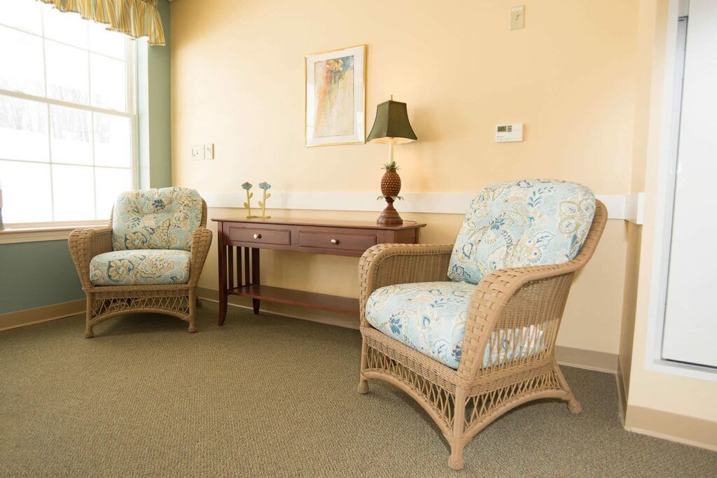 A living room with two wicker chairs and a desk.