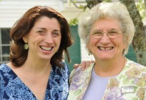 Two women are posing for a picture and smiling for the camera.