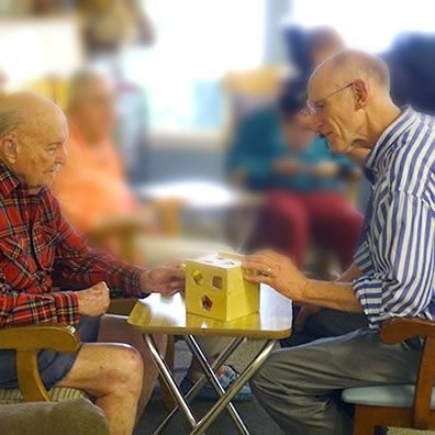 Two men are sitting at a table playing a game of chess.