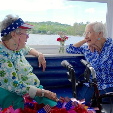 Two elderly women are sitting on a boat talking to each other