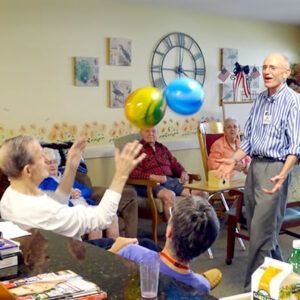 A man in a striped shirt is talking to a group of people