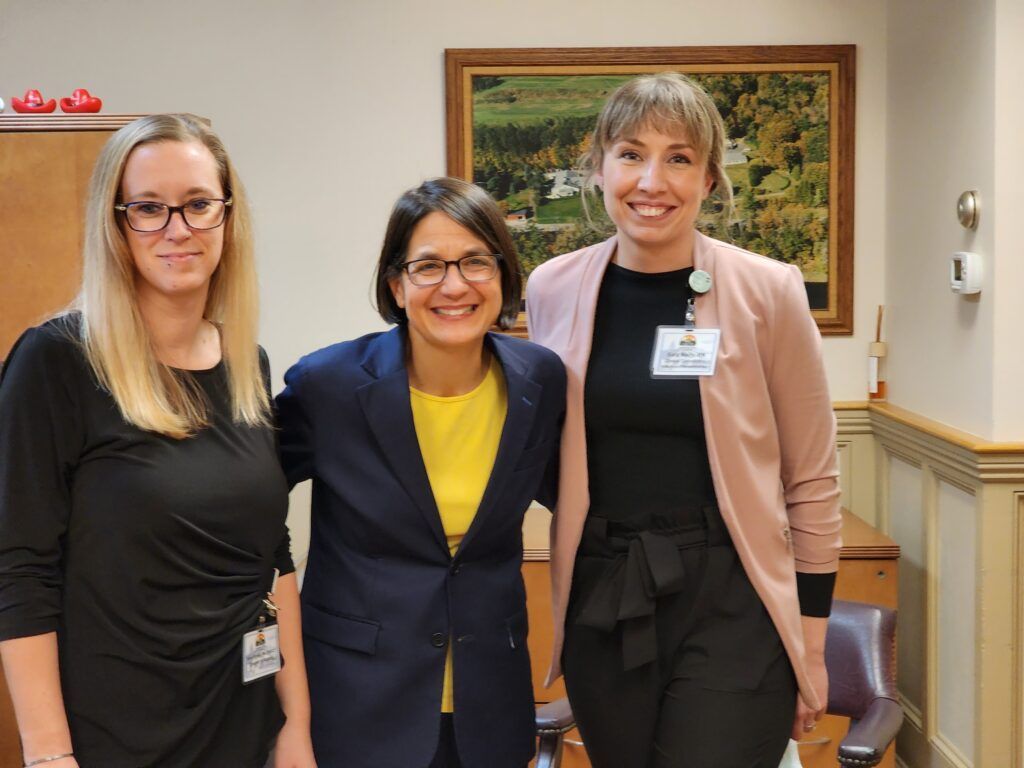 Three women are posing for a picture together in a room.