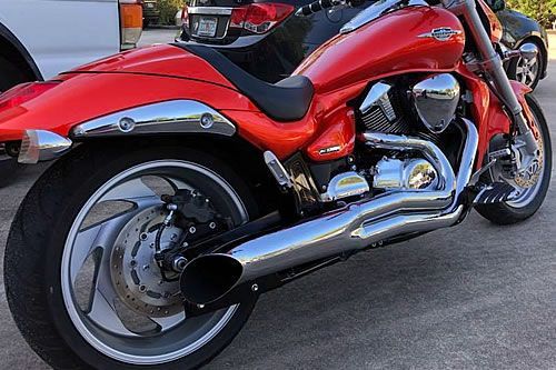 Red motorcycle with chrome accents parked outdoors.