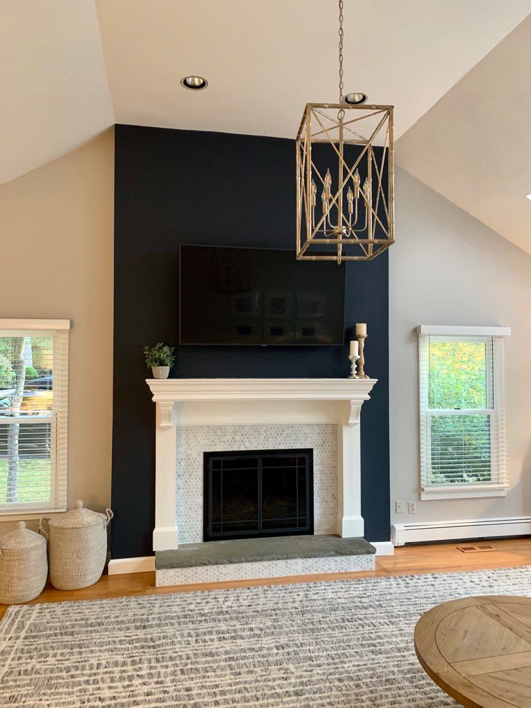 A living room with a fireplace and a flat screen tv on the wall.