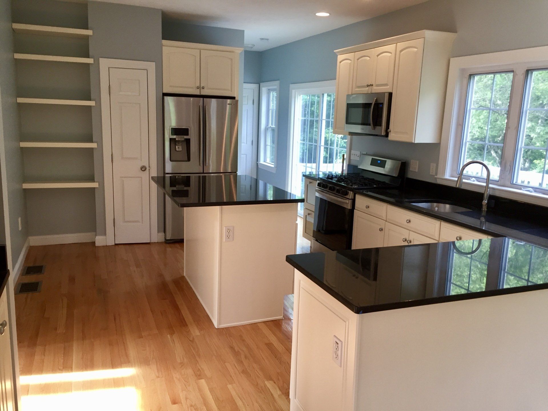 A kitchen with stainless steel appliances and black counter tops