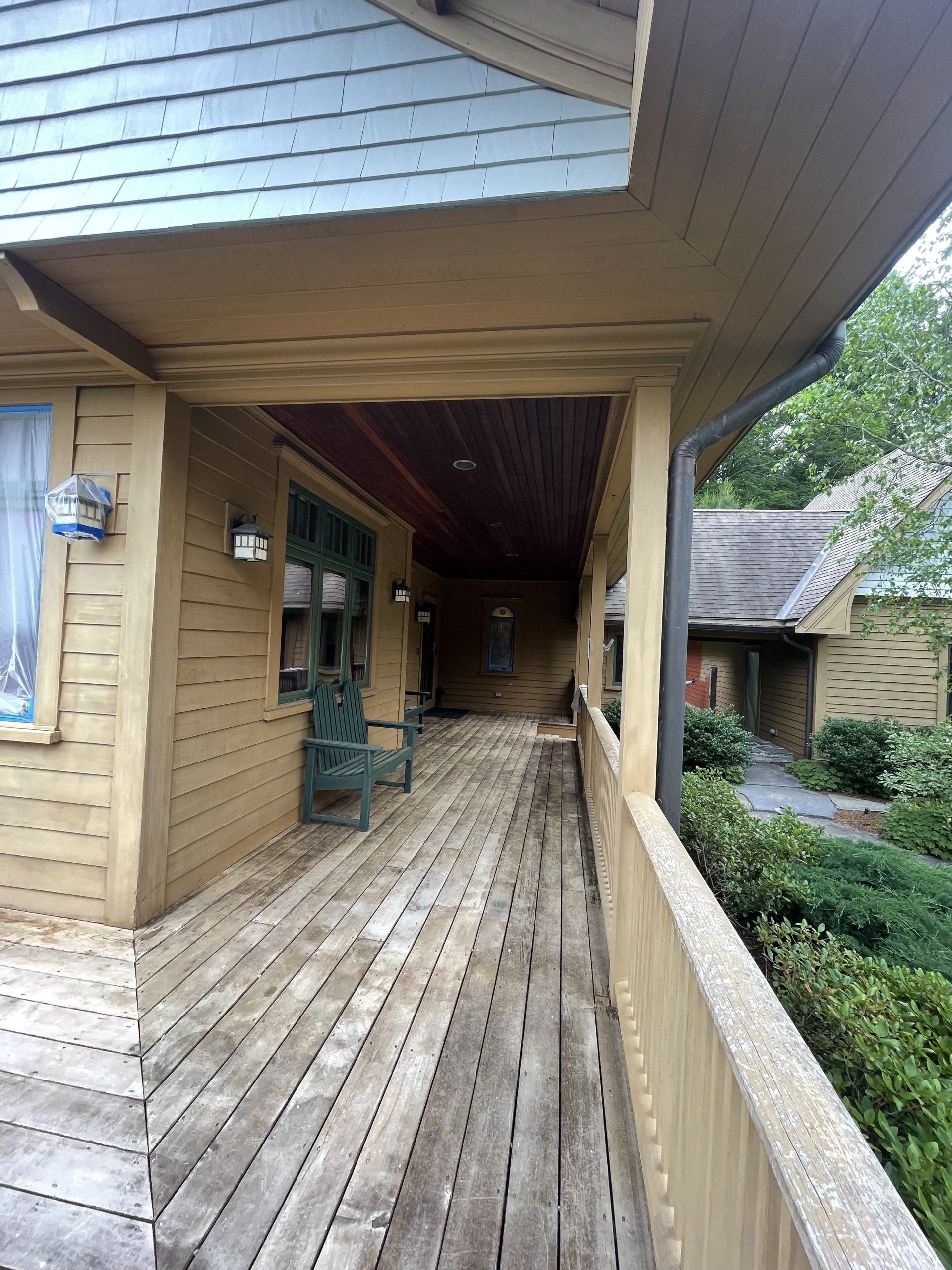 A long wooden walkway leading to a house that needs deck refinishing