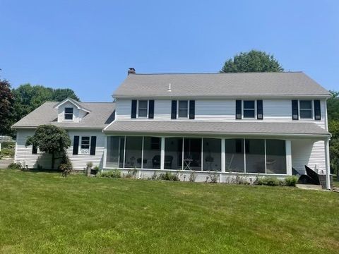 A large white house with a screened in porch