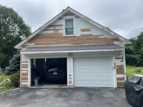 A white garage with a car parked inside of it.