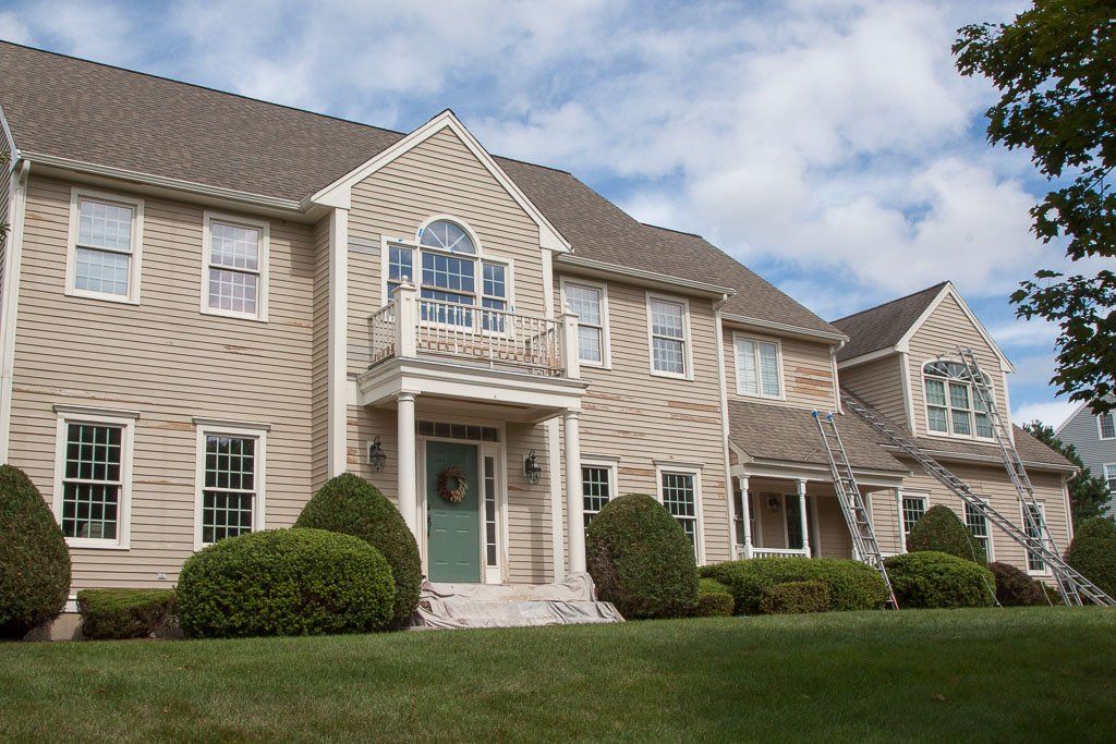 A large house with a green door and white trim