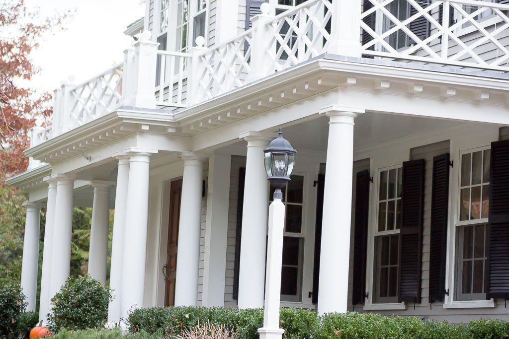 A large white house with black shutters and columns