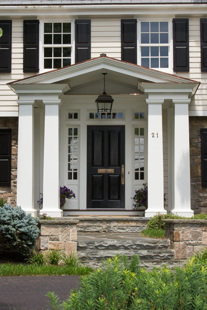 A white house with black shutters and a black door