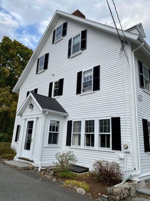 A white house with black shutters on the windows