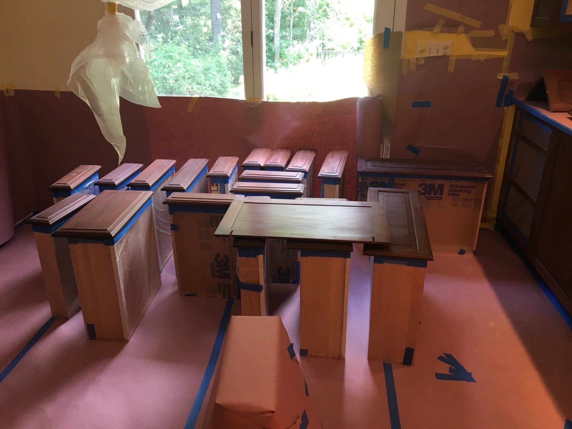 A room with boxes on the floor and a 3m tape on the floor. Cabinet Painting