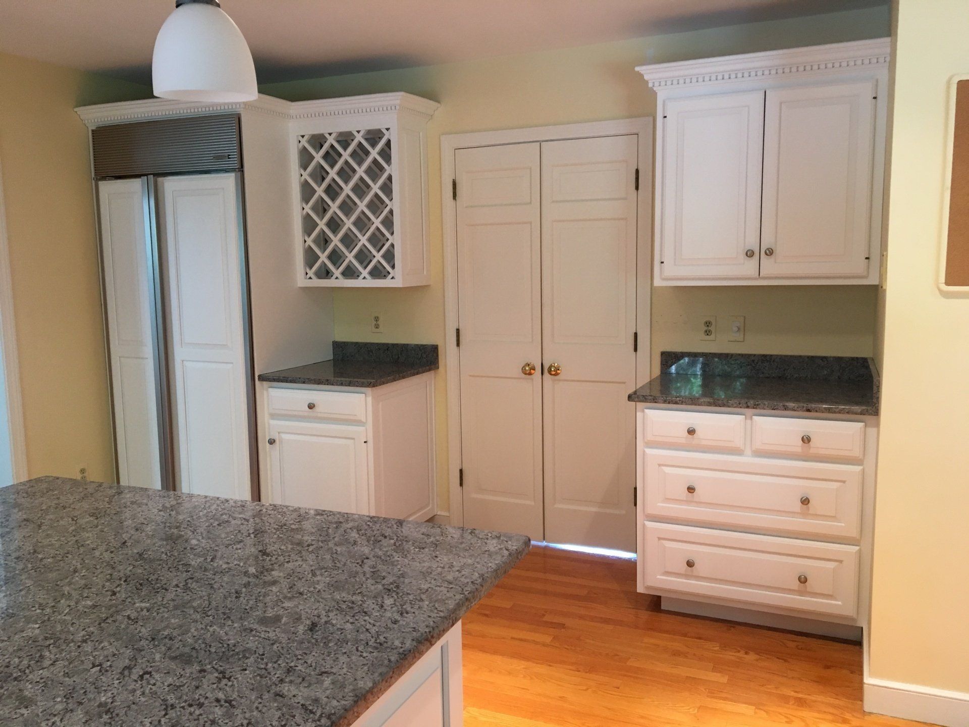 A kitchen with white cabinets and granite counter tops
