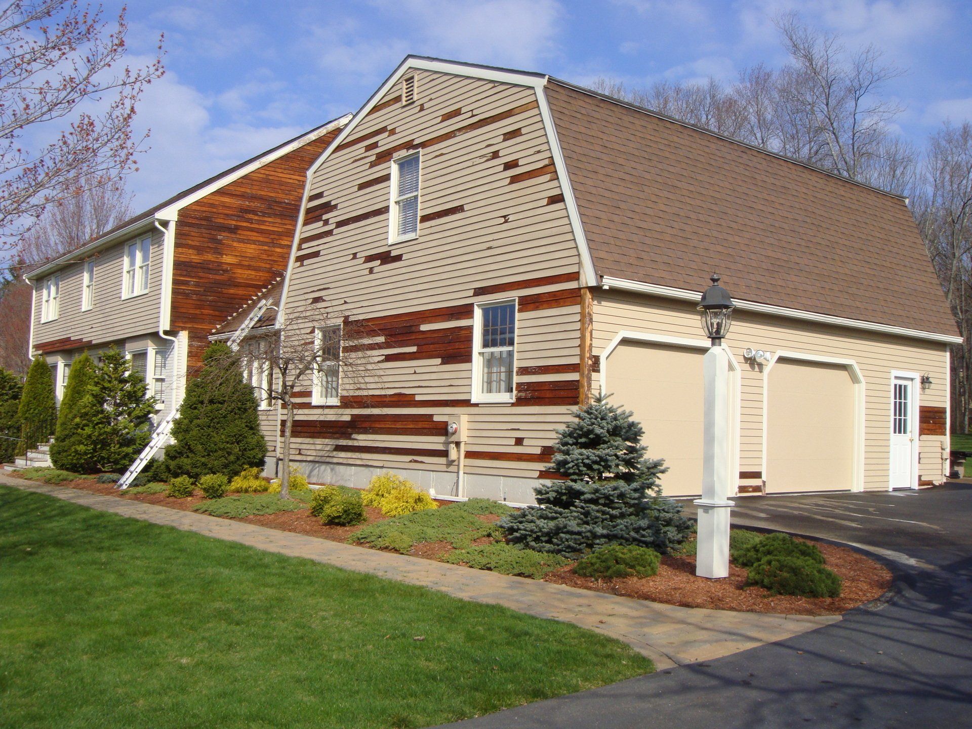 A house with a barn shaped roof and two garages