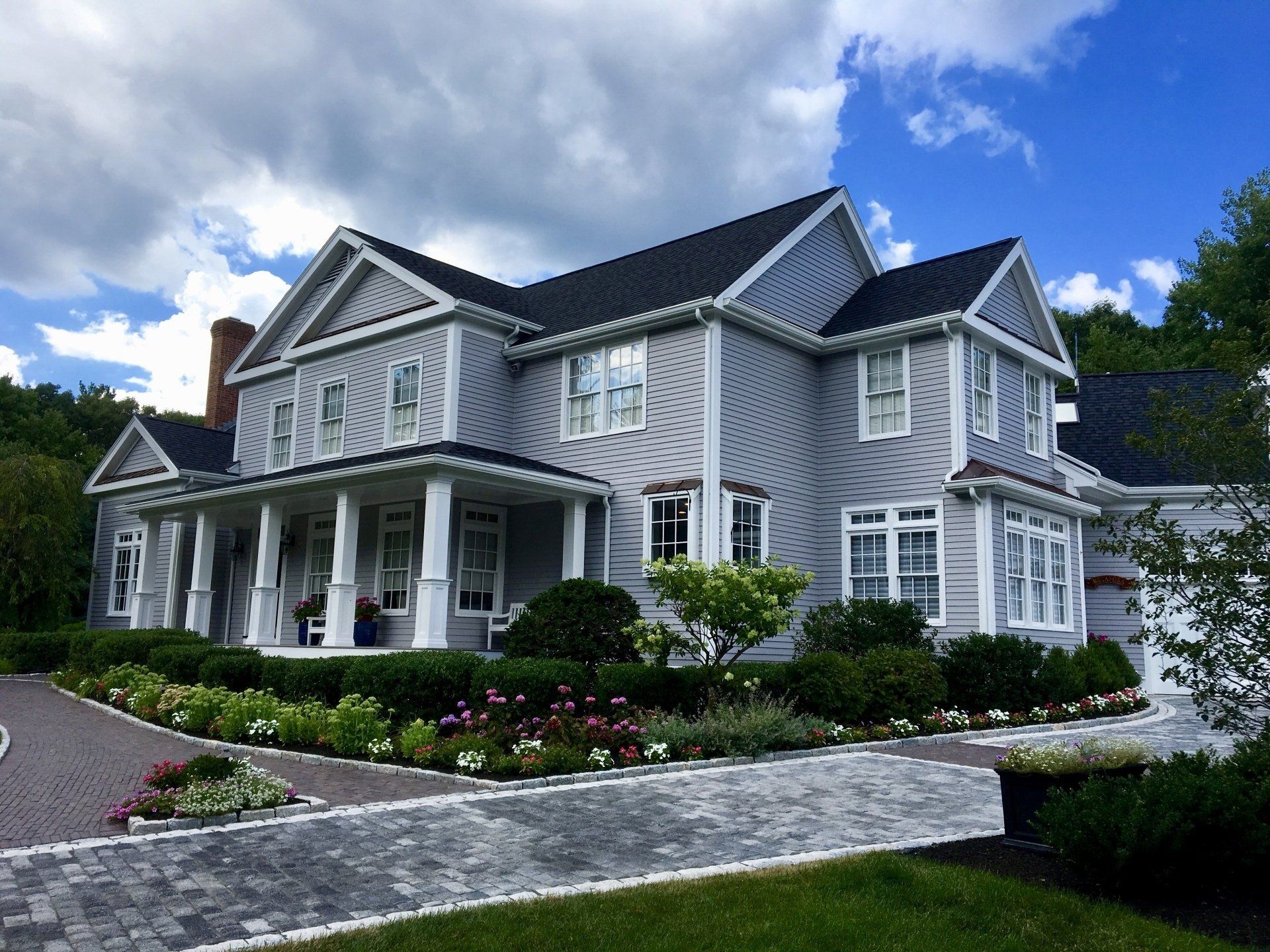 A large white house with a black roof and a large porch