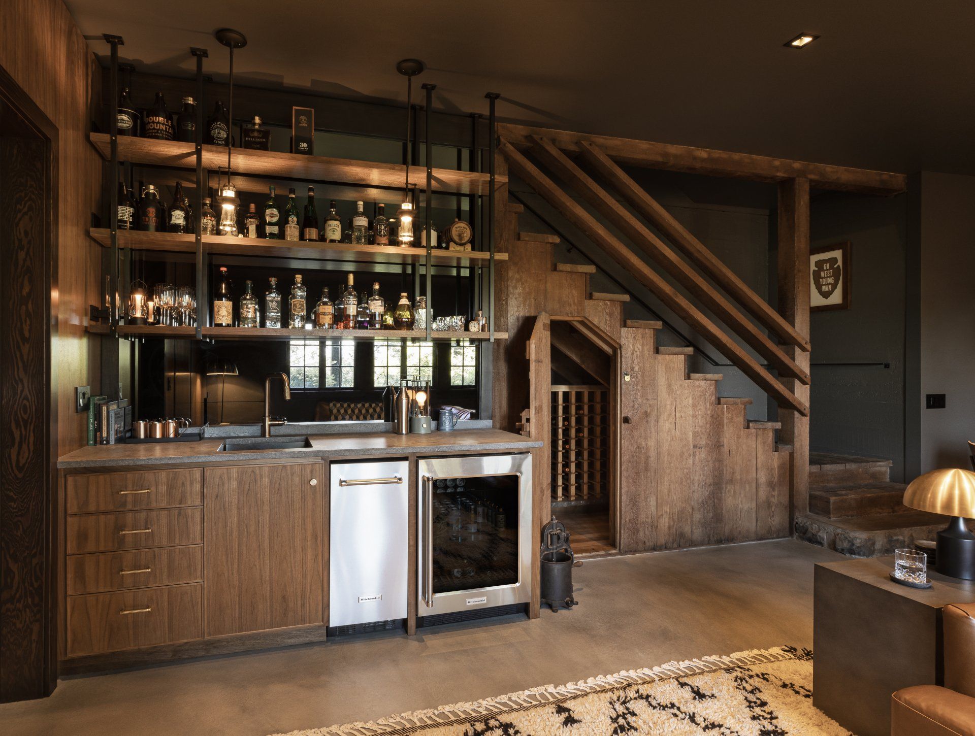 In the basement bar, the mirrored backsplash bounces natural light into the cozy room.