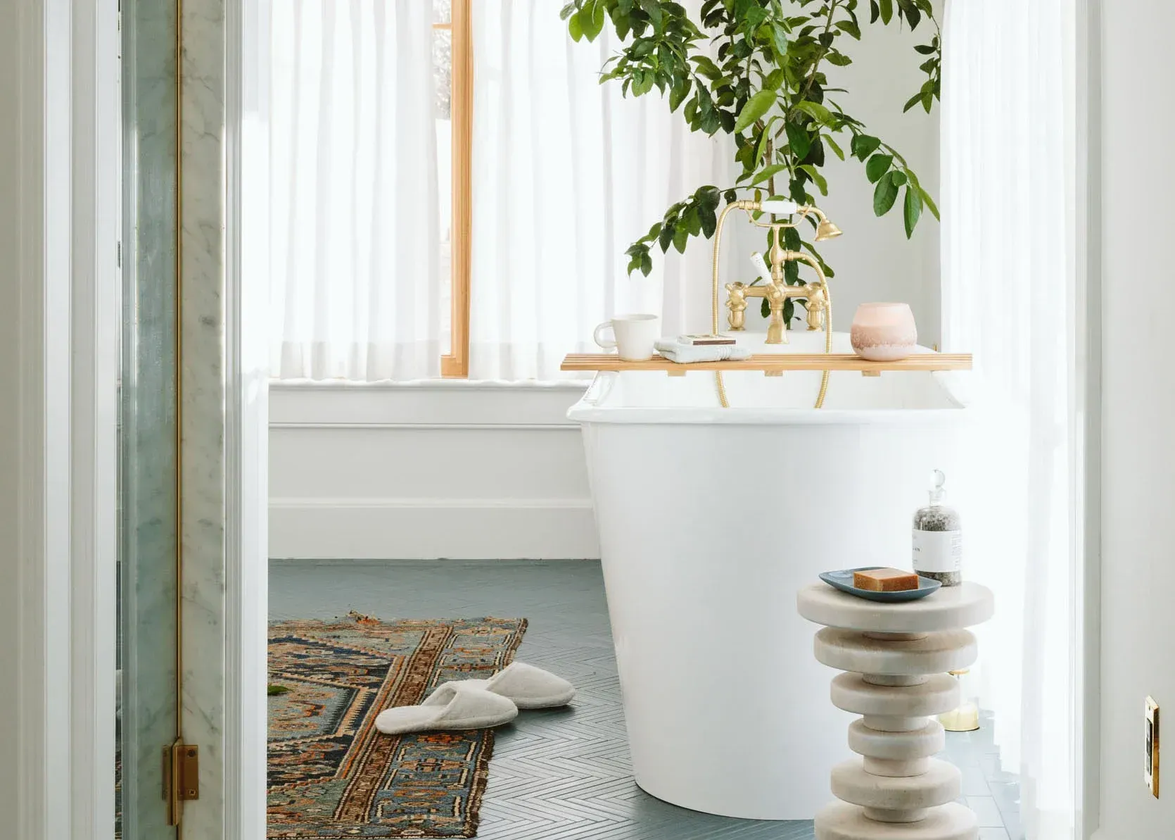A bathroom with a tub and a plant on the wall.