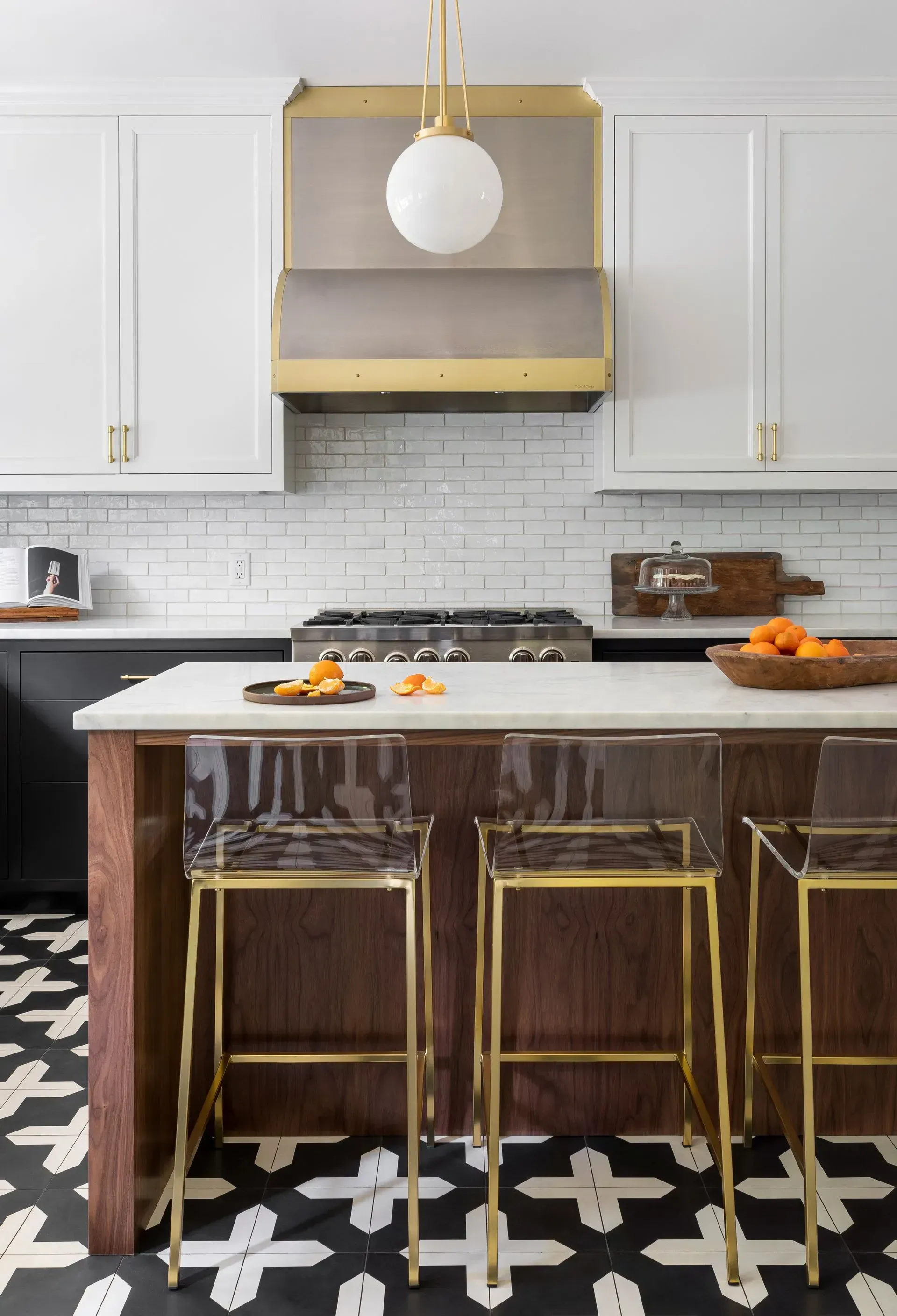 A kitchen with a large island , stools and a stove.